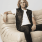 Men's rugged contemporary fashion featuring a stylish black leather riding vest layered perfectly over a casual shirt.