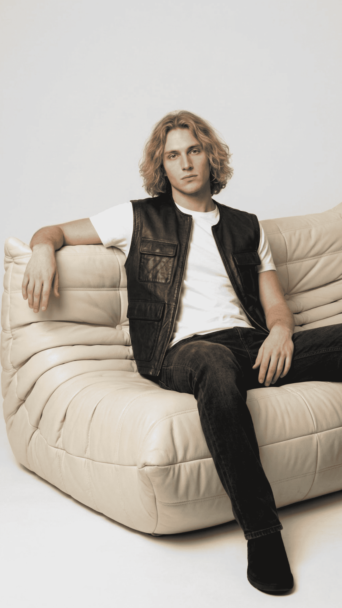 Men's rugged contemporary fashion featuring a stylish black leather riding vest layered perfectly over a casual shirt.