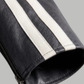Close-up of a black leather jacket with white stripes on a gray background