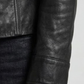 Close-up micro detail focusing on the flawless texture of the premium black genuine leather and branded metallic button accents.