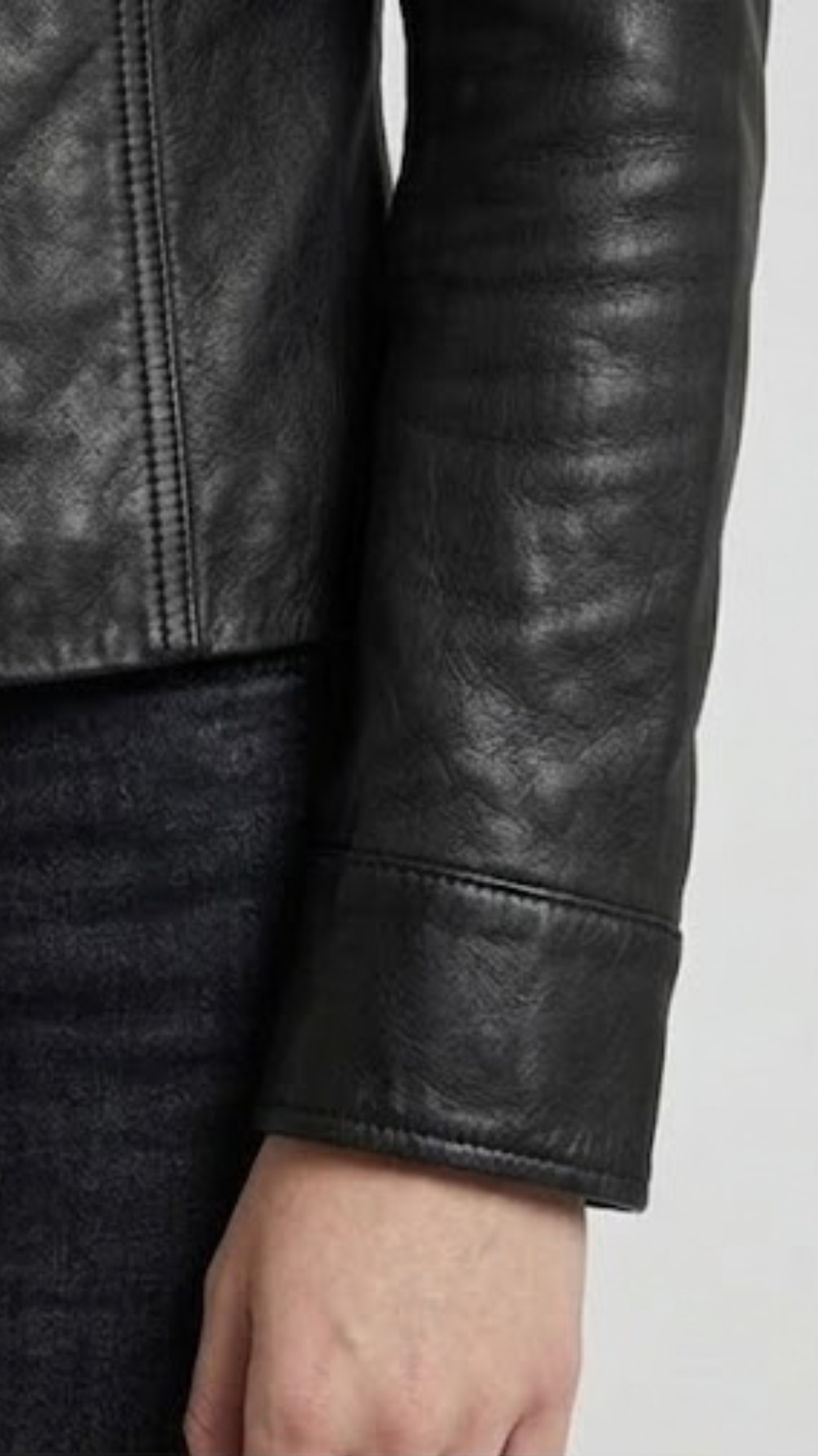 Close-up micro detail focusing on the flawless texture of the premium black genuine leather and branded metallic button accents.