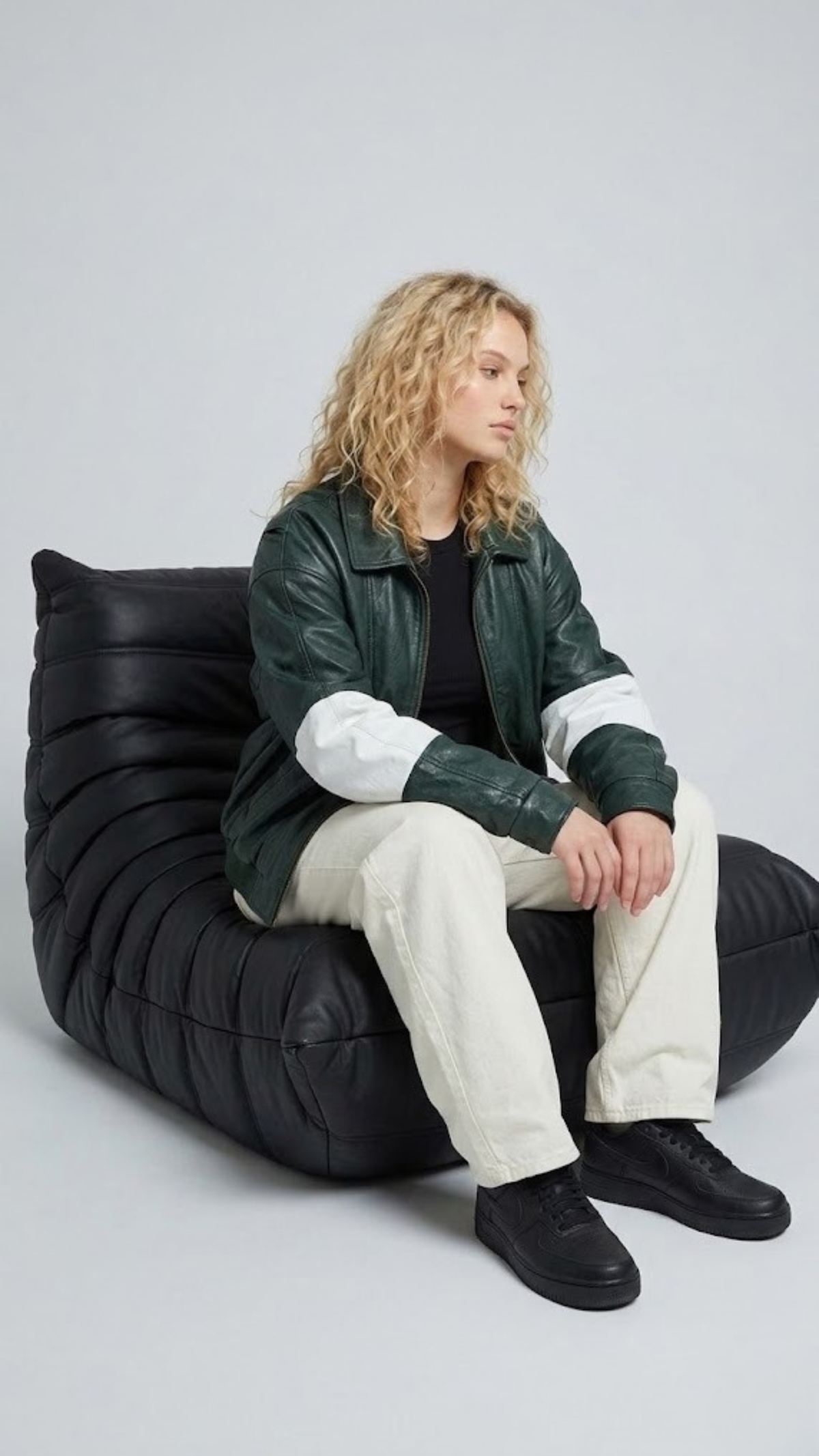 Modern urban streetwear fashion look featuring a loose-fitting green and white striped leather jacket styled for a contemporary lifestyle vibe.
