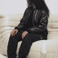 Modern urban lifestyle fashion presentation featuring a versatile black leather flight bomber jacket, perfect for smart-casual winter layers.