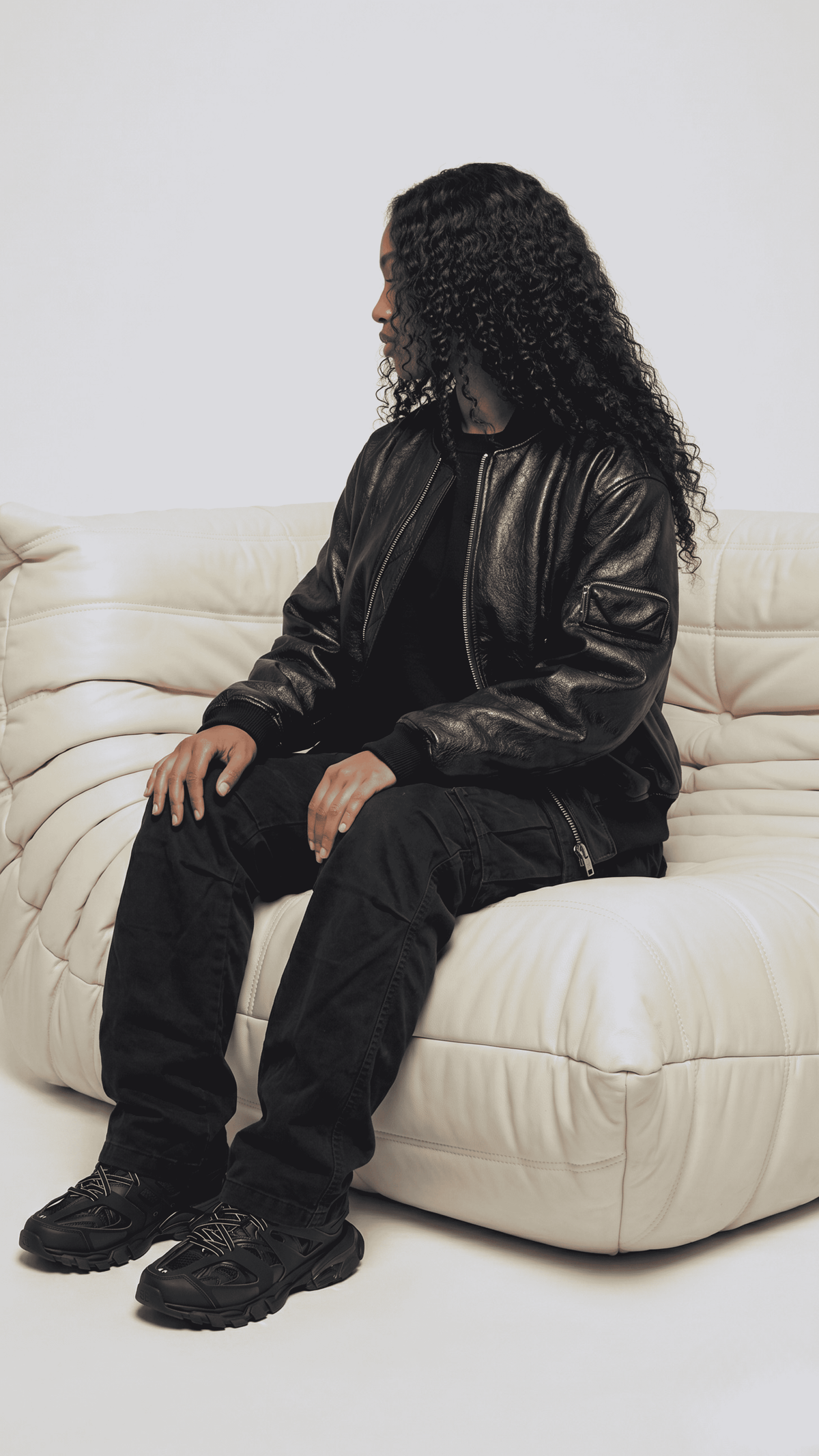 Modern urban lifestyle fashion presentation featuring a versatile black leather flight bomber jacket, perfect for smart-casual winter layers.