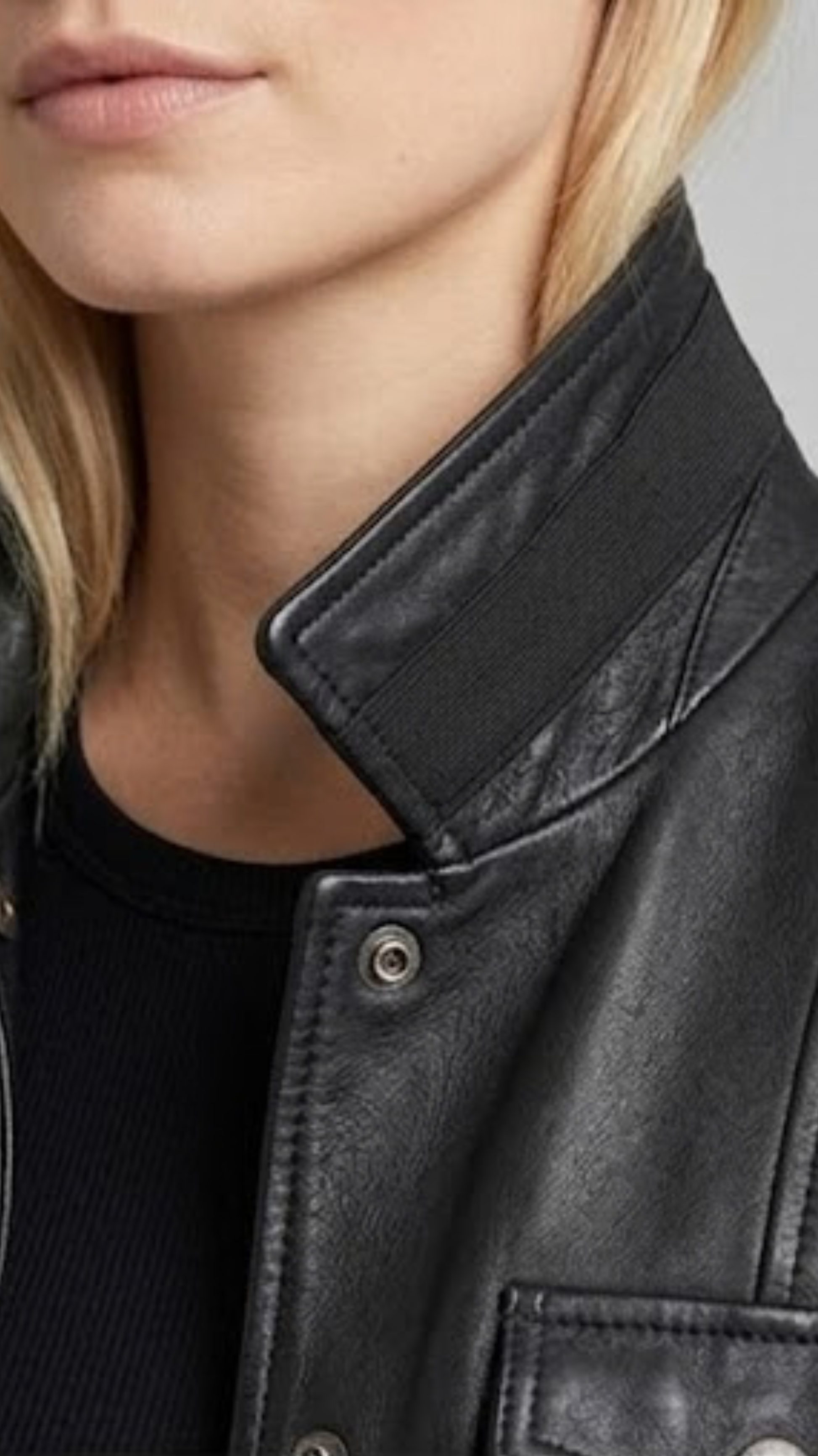 Close-up of a person wearing a black leather jacket with a blurred background