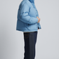 Symmetrical side pose of a cozy pastel light blue quilted jacket featuring a high collar for wind protection.