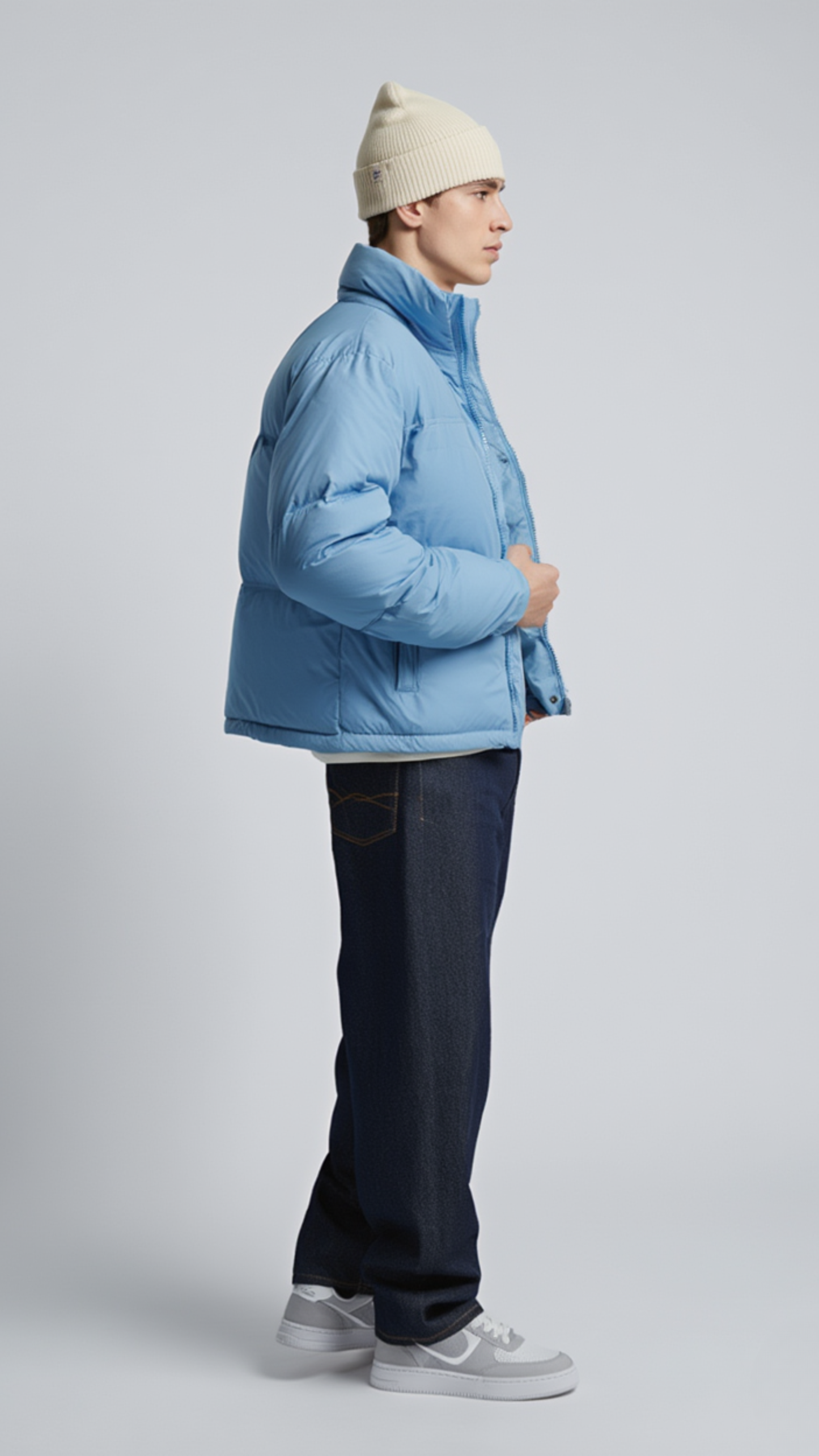 Symmetrical side pose of a cozy pastel light blue quilted jacket featuring a high collar for wind protection.
