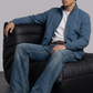 Men's contemporary high-fashion statement featuring a sleek turquoise silk cotton bomber jacket styled for an upscale casual look.