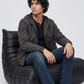 Men's contemporary high-fashion presentation featuring a sleek dark grey hooded jacket styled for a modern street-luxe look.