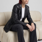 Women's contemporary high-fashion presentation featuring a sleek black leather blazer styled for a bold, modern look.