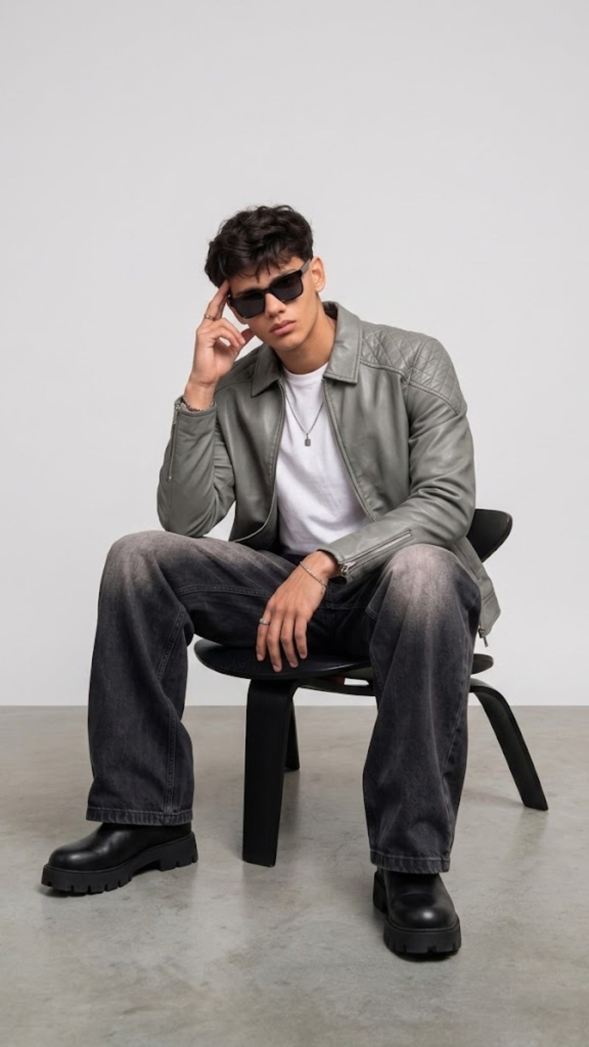 Detailed view of the neat collar stitching, durable silver zippers, and clean panel lines on a men's grey leather outerwear.