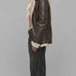 Side-angle profile view displaying the comfortable relaxed Y2K baggy fit of a men's dark brown leather bomber with soft shearling accents.