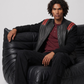 Men's contemporary urban fashion featuring a structured black and red leather bomber jacket styled for a sharp, sporty streetwear look.