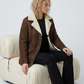 Men's luxury winter fashion featuring a sophisticated long-line dark brown suede coat with warm fur trim.