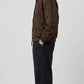 Side profile view displaying the comfortable broad shoulder drop and relaxed slouchy baggy fit of a men's dark chocolate suede outerwear.