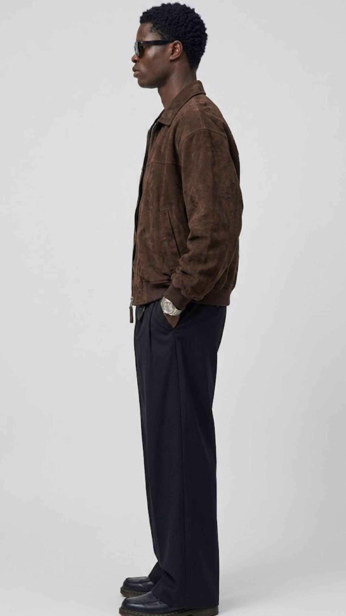Side profile view displaying the comfortable broad shoulder drop and relaxed slouchy baggy fit of a men's dark chocolate suede outerwear.