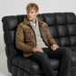Men's rugged heritage fashion featuring a structured brown distressed leather military jacket styled for an authentic vintage look.