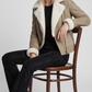 Women's sophisticated winter fashion featuring a stylish sand-colored suede jacket with warm shearling collar trim.