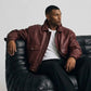 Detailed view of side waist slash pockets and flexible elasticated ribbed cuffs on maroon leather outerwear.