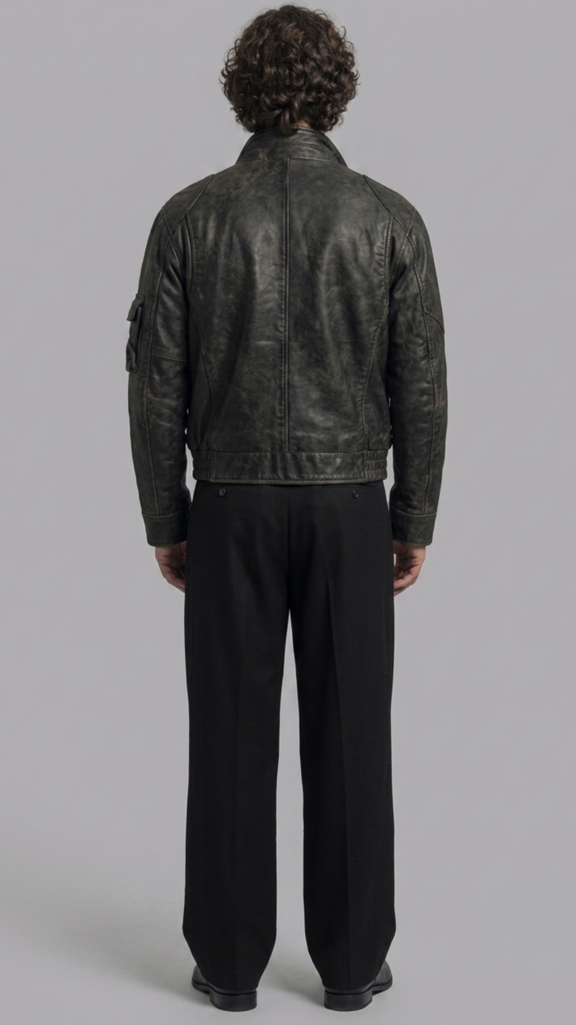 Regular fit men's vintage black leather outerwear displaying clean zippered side pockets and reinforced shoulder panels.