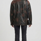 Straight-on back view of a minimalist black leather trucker jacket showcasing its structured paneling and tailored vintage look.