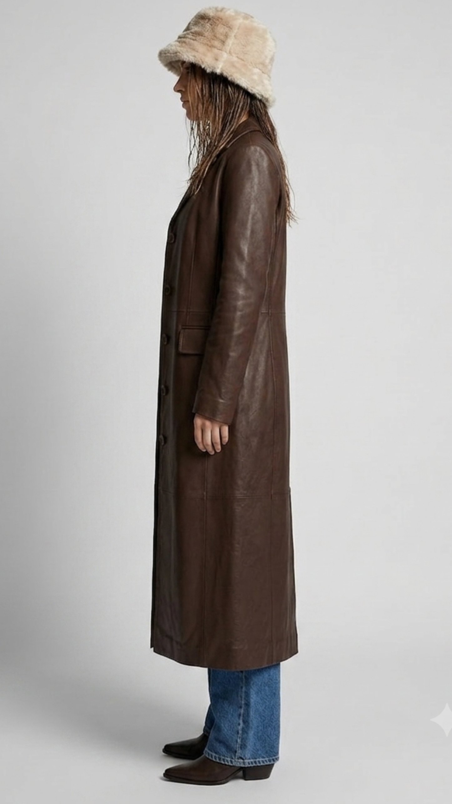 Studio photography showcasing the structured silhouette of a long leather trench coat.