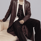 Detailed view of dark red leather waist belt buckle and side pockets on a long leather trench coat