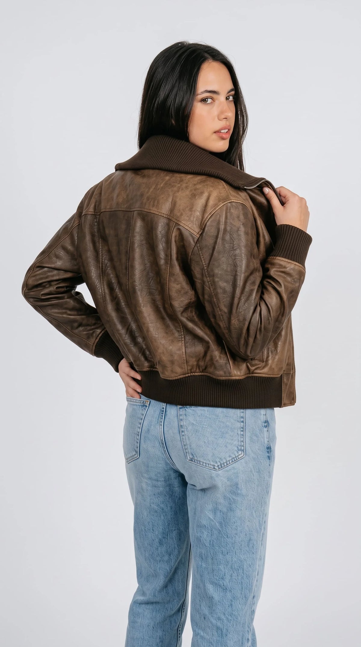 Retro Y2K style brown leather bomber jacket for women with oversized ribbed collar, worn open over a white ribbed tank