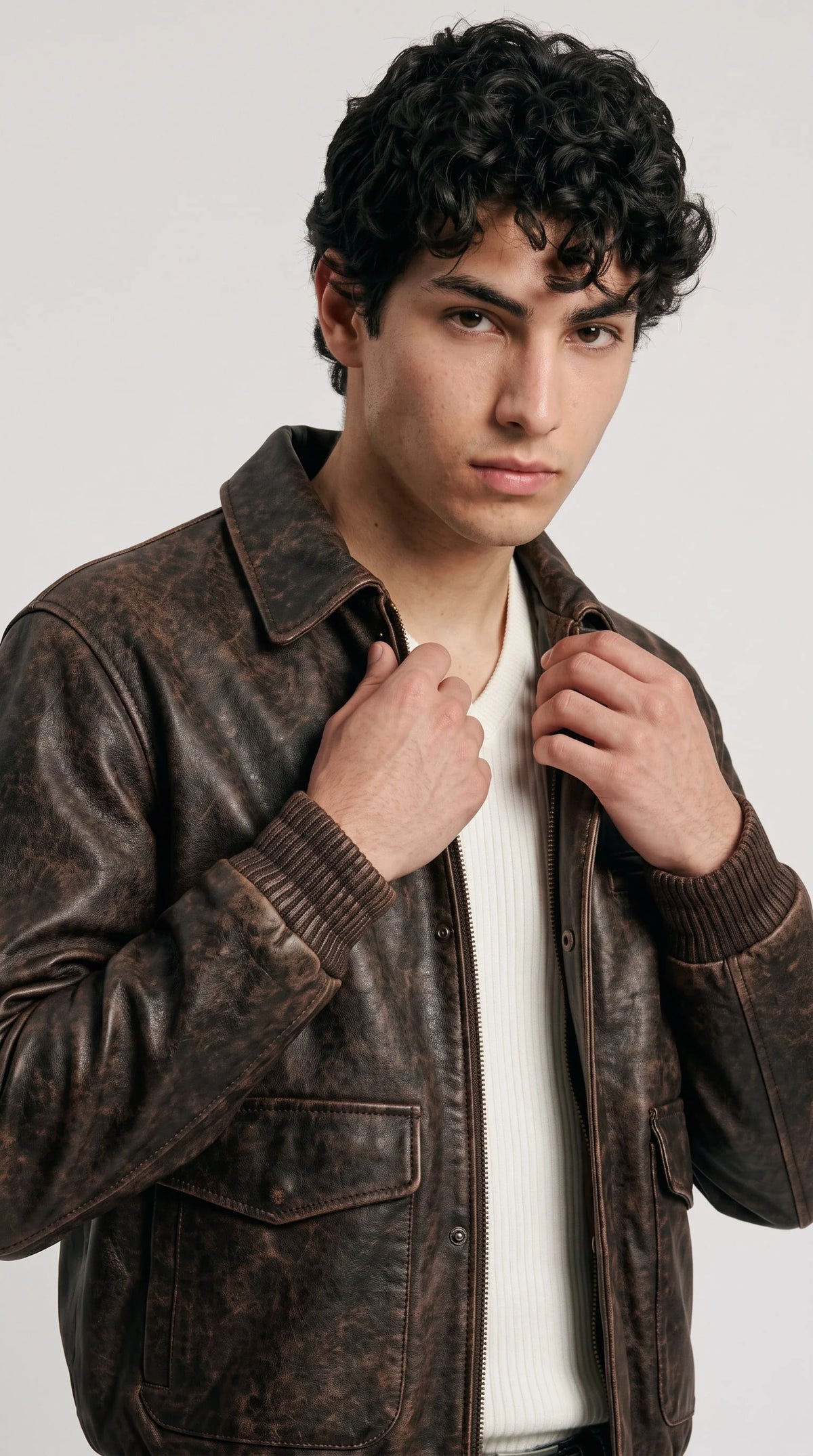 Antique dark chocolate leather flight jackero jacket for men in slim fit, styled with white ribbed sweater and washed black jeans