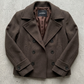 Detailed view of the texture and fabric quality of a dark brown short winter wool pea coat