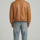 Men's tan aviator bomber leather jacket with thick cream shearling trim on collar and cuffs.