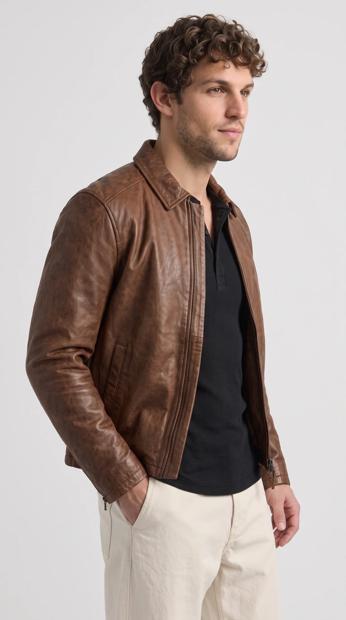 Warm brown genuine leather jacket with a relaxed contemporary fit, structured shoulders, long leather sleeves and discreet side-entry waist pockets, creating a versatile minimalist outerwear look that works with neutral trousers and understated casual layers.