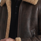 Close-up shot highlighting the premium dark brown leather texture and contrast tan shearling collar details.