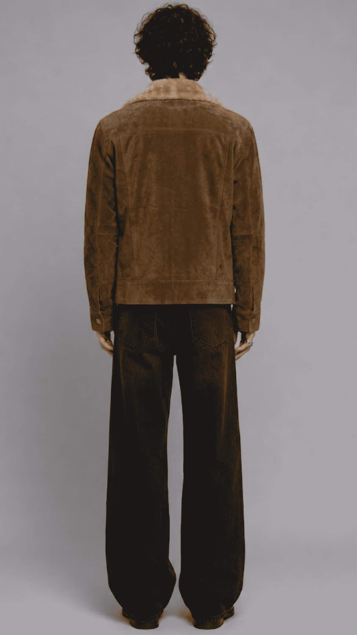 highlighting the rich velvety texture of dark mustard yellow suede paired with soft fur lining along the collar edges.