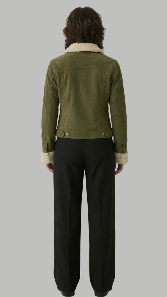 Person wearing a green jacket with a white collar and black pants on a gray background