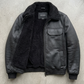 Close-up detail showcasing the premium grain black leather paired with thick, soft black shearling.