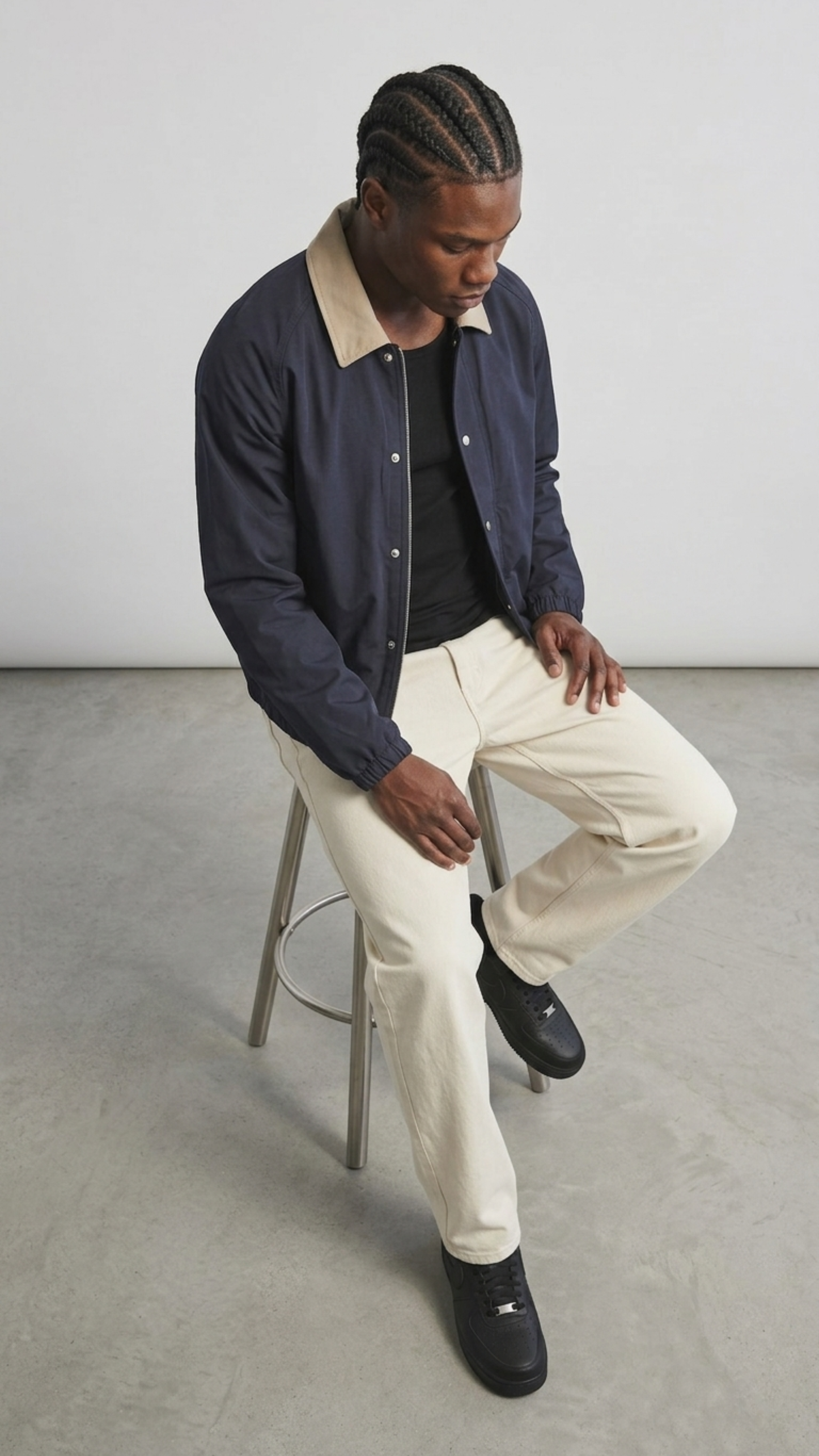 the premium matte snap buttons and dense dark blue cotton weave texture on the front placket of the coach jacket.