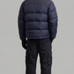 back profile showing the puffy texture and clean design of a dark navy winter outerwear piece.