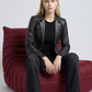 Women's sophisticated fashion showcasing a structured black leather suit jacket styled for a modern smart-formal look.