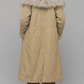 Back view displaying the clean hemline, center vent, and longline silhouette of a light yellow cotton overcoat.