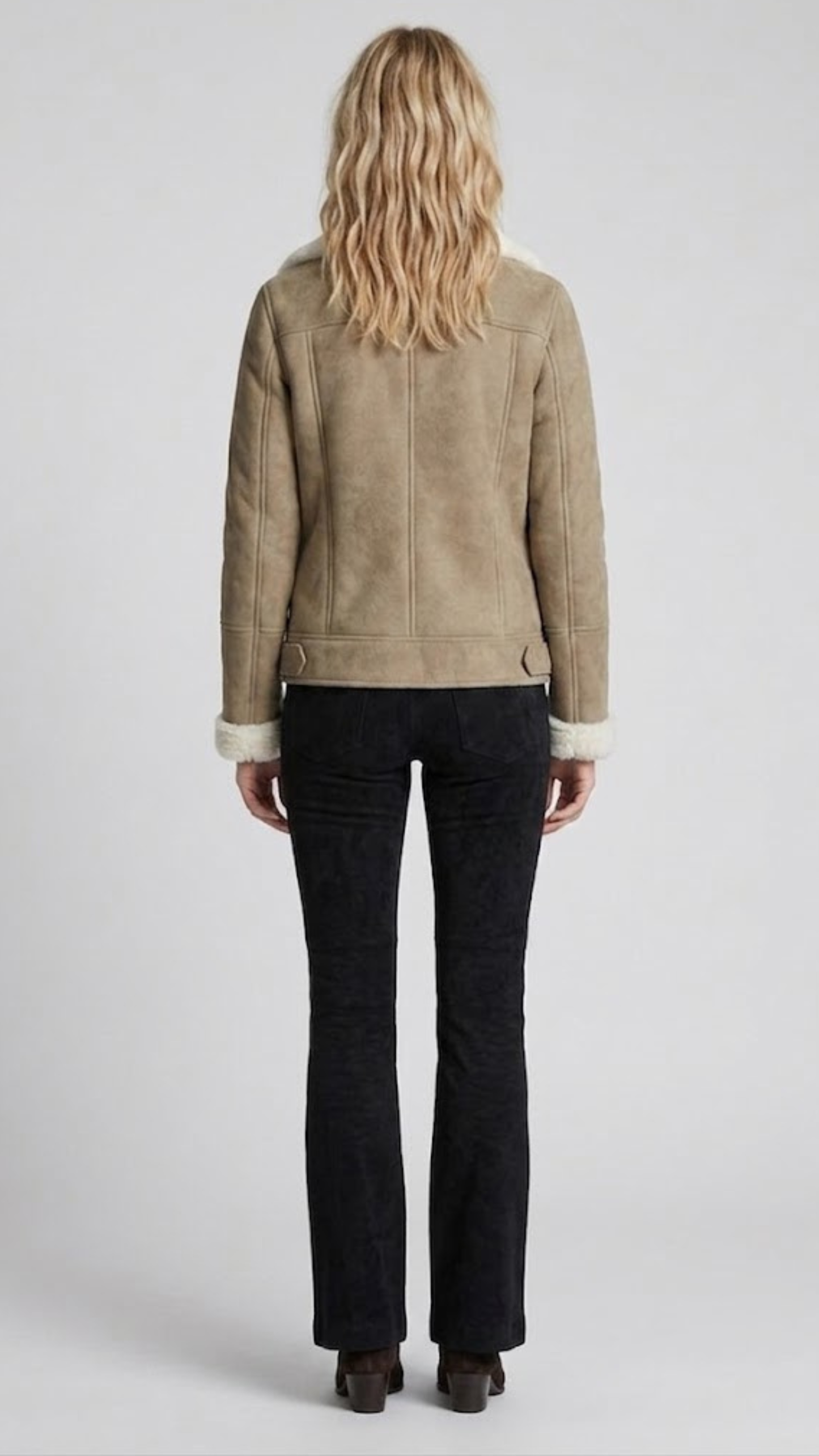 Regular fit beige suede shearling jacket layered over a casual knitted sweater for a modern urban aesthetic.