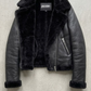 symmetrical jacket lookbook photography of a women's black leather coat with a distinctive shearling collar.