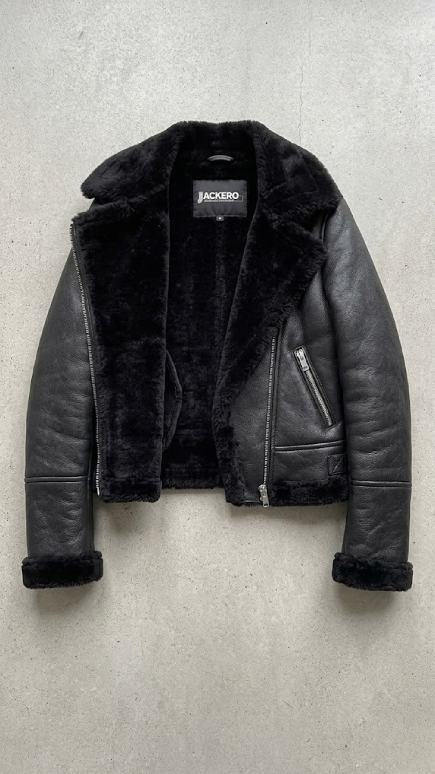 symmetrical jacket lookbook photography of a women's black leather coat with a distinctive shearling collar.
