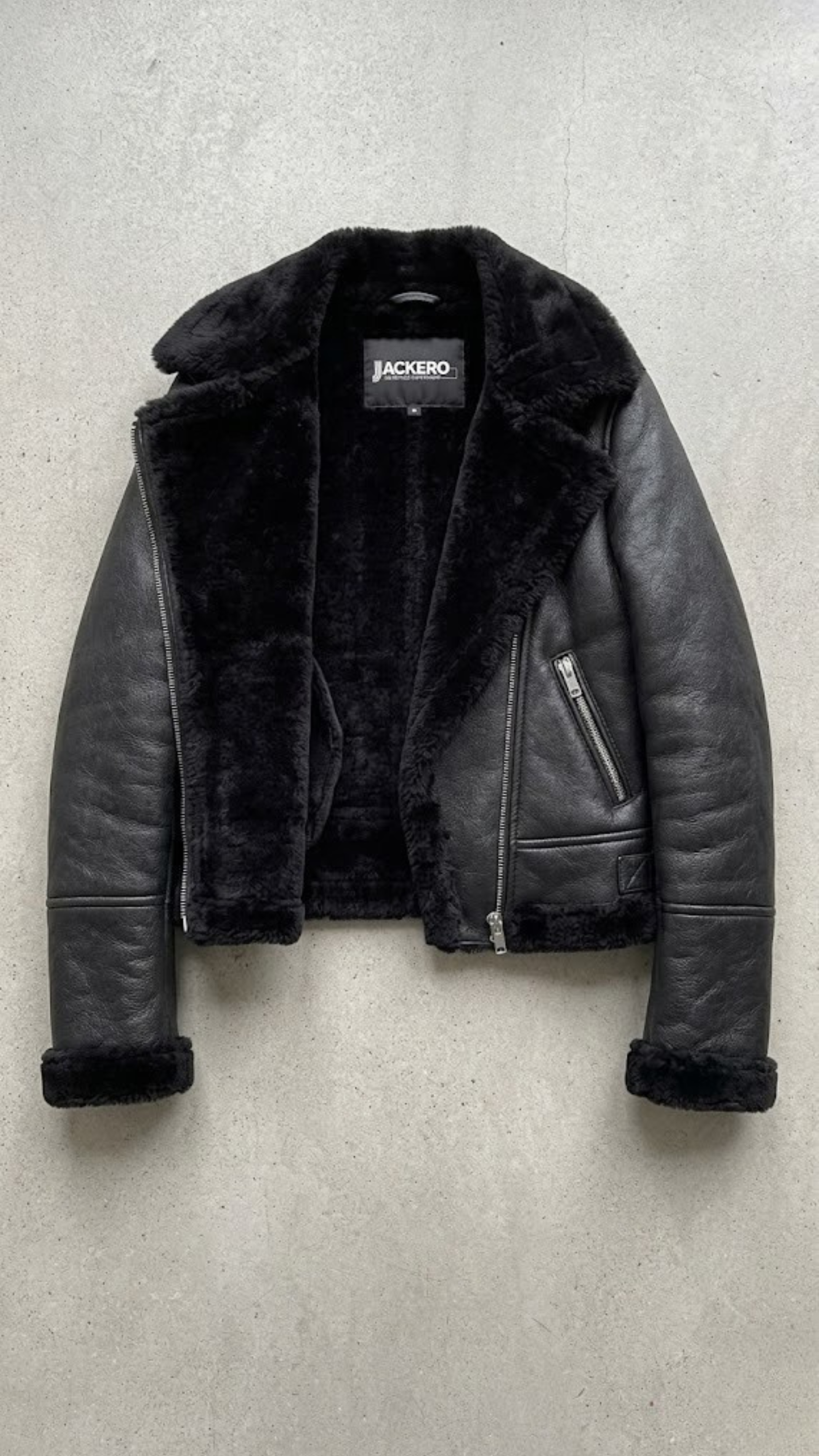 symmetrical jacket lookbook photography of a women's black leather coat with a distinctive shearling collar.
