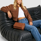 Women's contemporary high-fashion presentation featuring a sleek beige cotton silk jacket styled for an upscale casual everyday look.