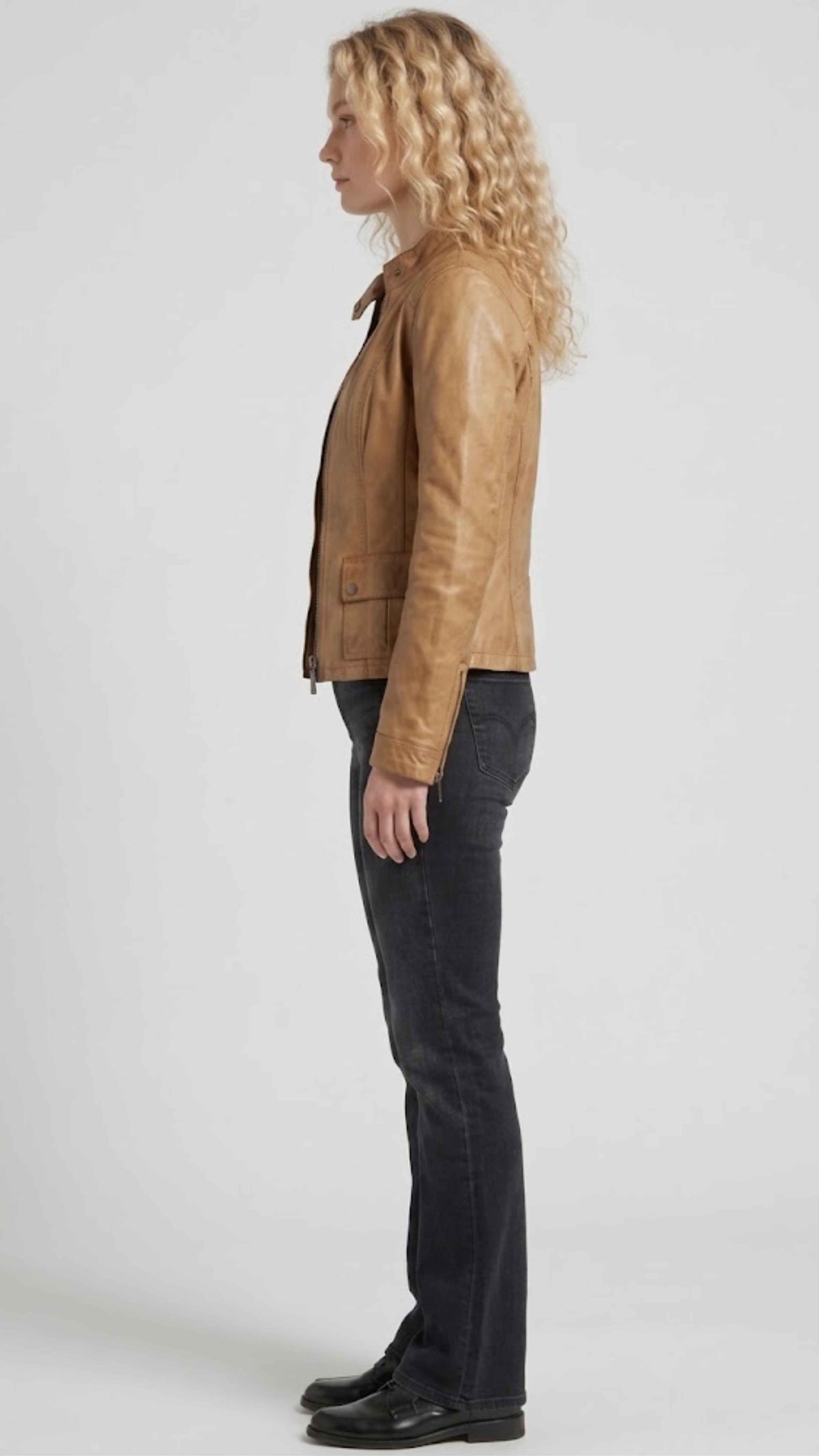 Women's tan leather jacket with stand collar and asymmetric zip, casual outfit styling