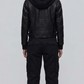 Symmetrical rear view studio shot highlighting the clean leather paneling and relaxed-fit hood drape of the black bomber coat.