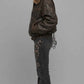 Side profile view displaying the comfortable relaxed Y2K baggy fit of a men's weathered dark brown leather bomber with soft fur accents.