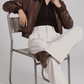 Full-body studio catalog shot of a women's crocodile-print brown leather bomber jacket on a grey backdrop.